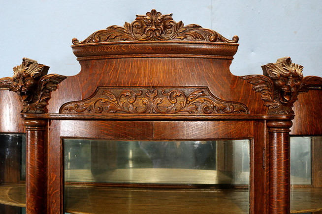 035c - Quarter sawn oak china cabinet with 4 shelves, curved glass front and carved lions heads, 76 in. T, 56 in. W, 19 in. D.