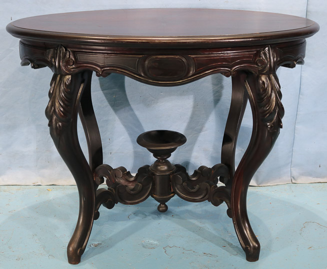 105a - Rosewood Victorian parlor table with cup finial, book match veneer top and carved stretcher, 29 in. T, 40 in. W, 28.5 in. D.-28