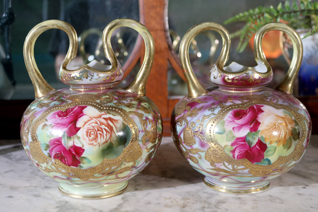 005 - Pair of hand painted Nippon double handle urns with gold enamel and painted roses, 8 in. T, 7 in. H-H
