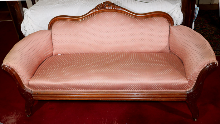 029a - Walnut Victorian loveseat with grape crest and pink upholstery, 31 in. T, 63 in. L, 16 in D.