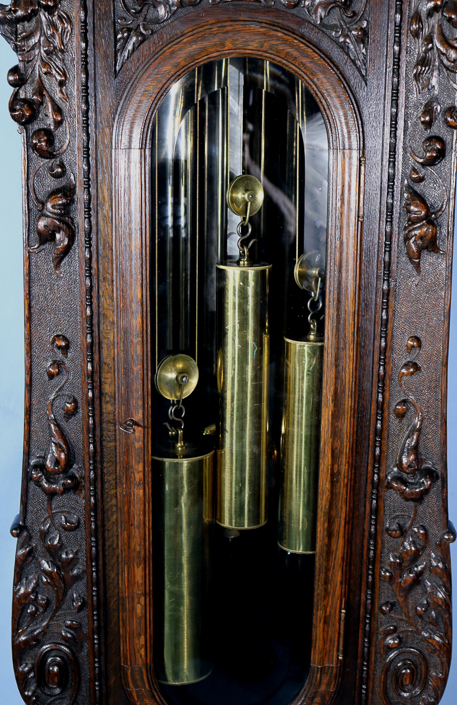 084f - Oak heavily carved 5 tube grandfather clock by R.J. Horner with Tiffany works, has carved figures and claw feet, 8 ft. 10 in. T, 27 in. W, 27 in. D.