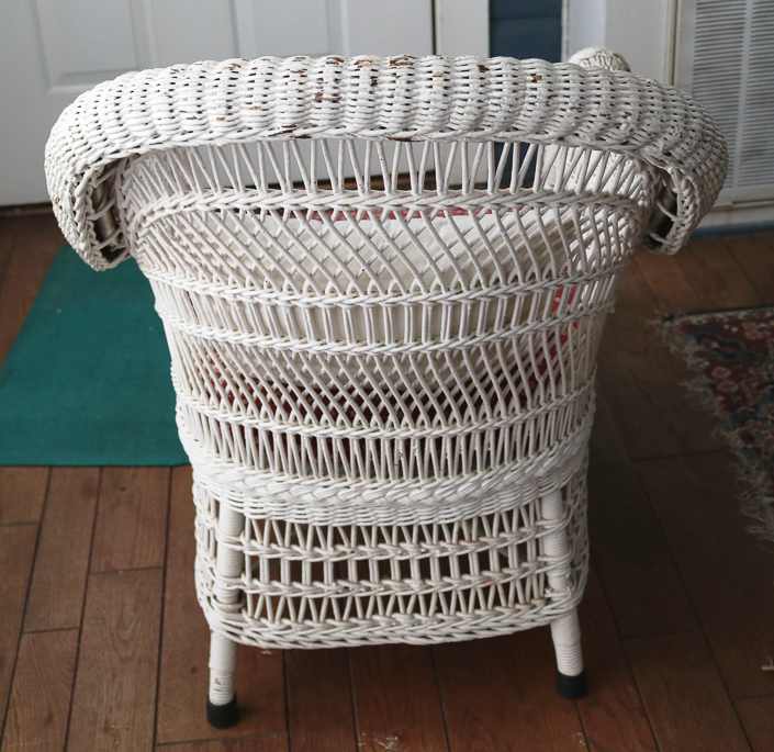 107c - Antique white wicker chair with rolled arms, original to this house, 33 in. T, 26 in. W, 20 in. D.